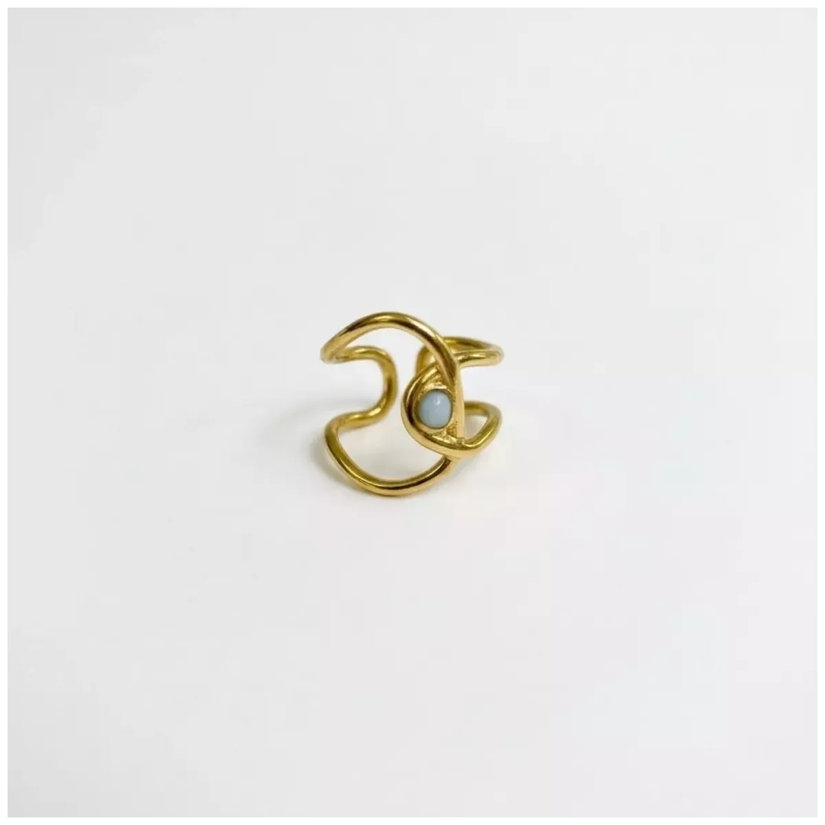 Bague vague ajourée et pierre blanche dorée